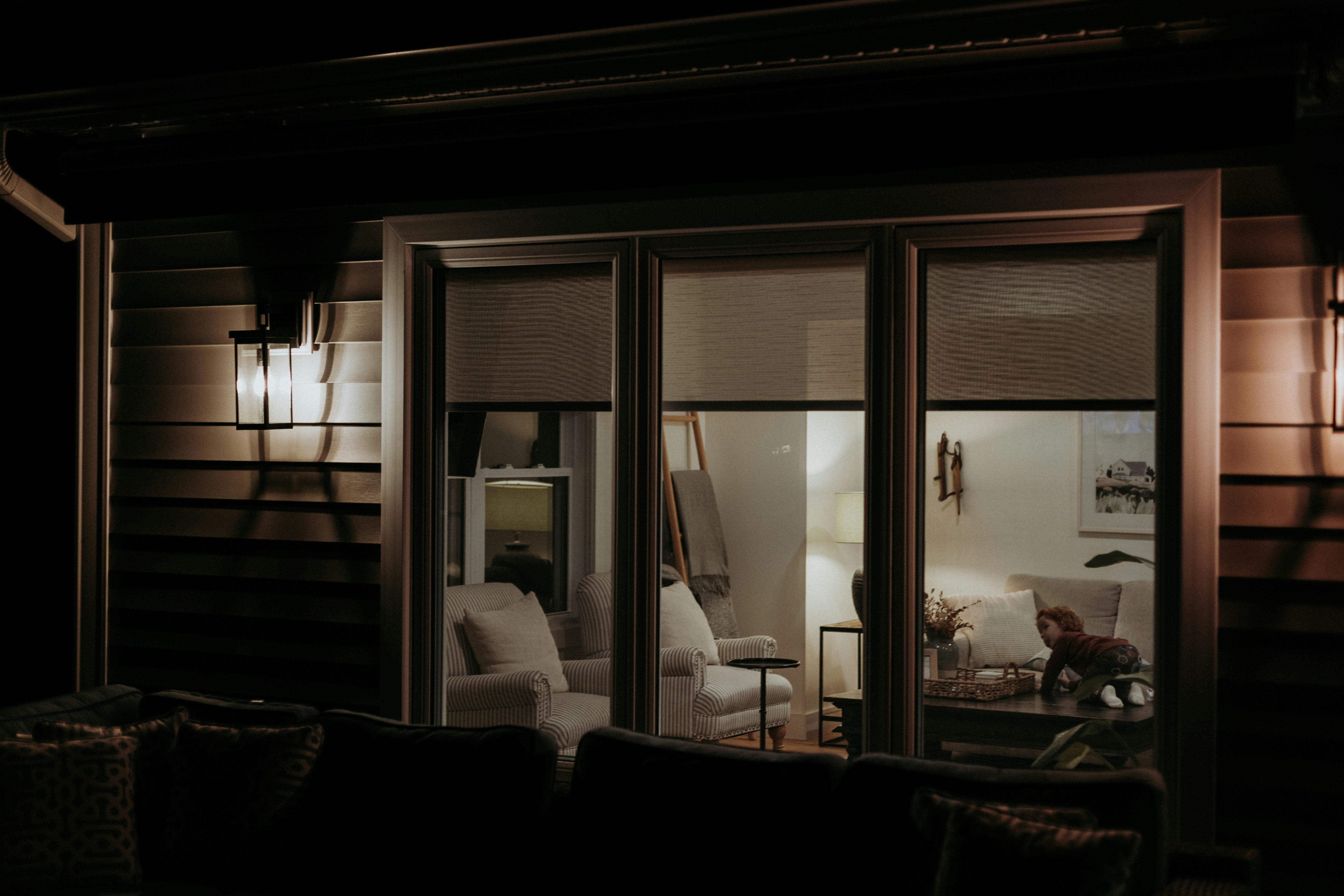 A dark room with a couch and a lamp