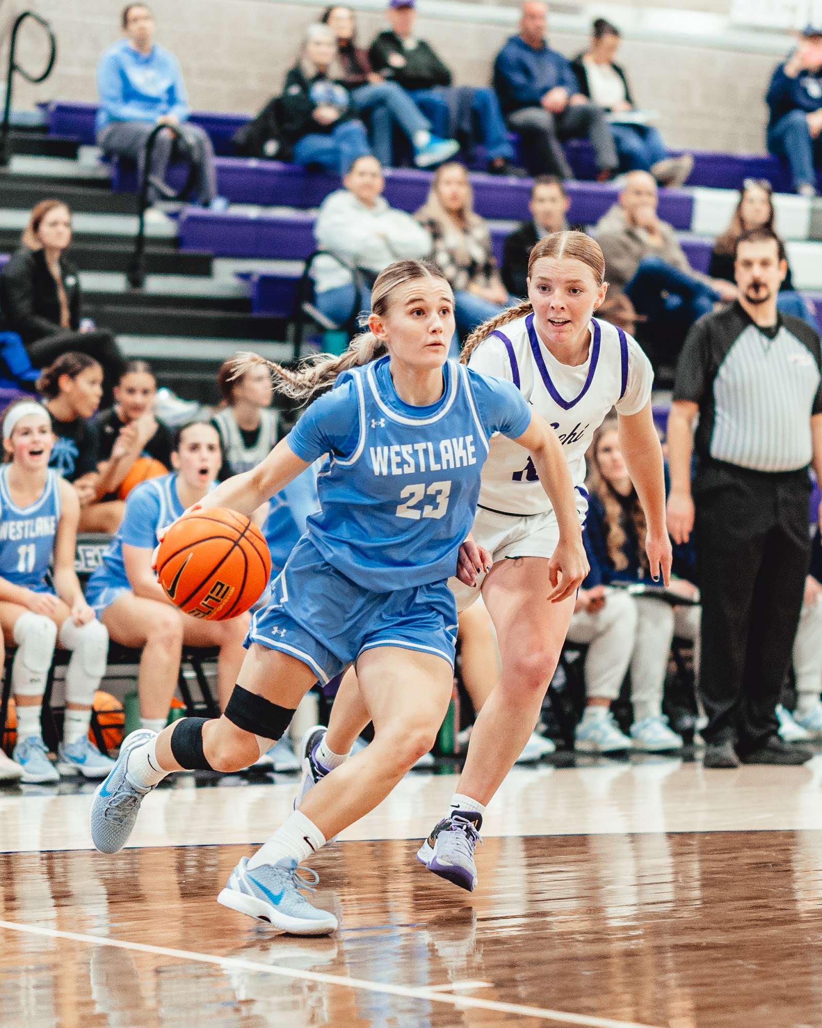 Three people sitting on a couch in a room looking at mobile devices