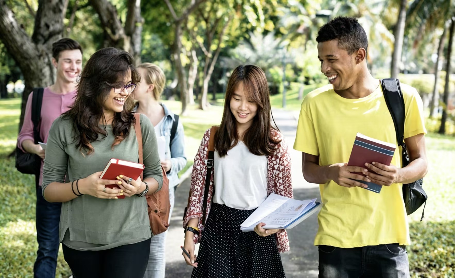 Diverse international students walking together in a park.