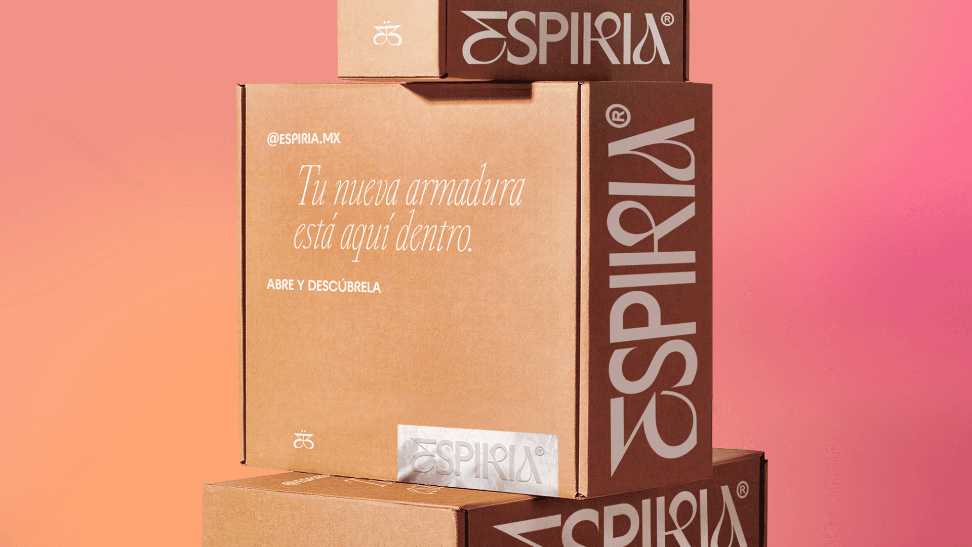 Stacked brown cardboard boxes with the "Espiria" logo and the phrase "Tu nueva armadura está aquí dentro" on a pink and orange gradient background.