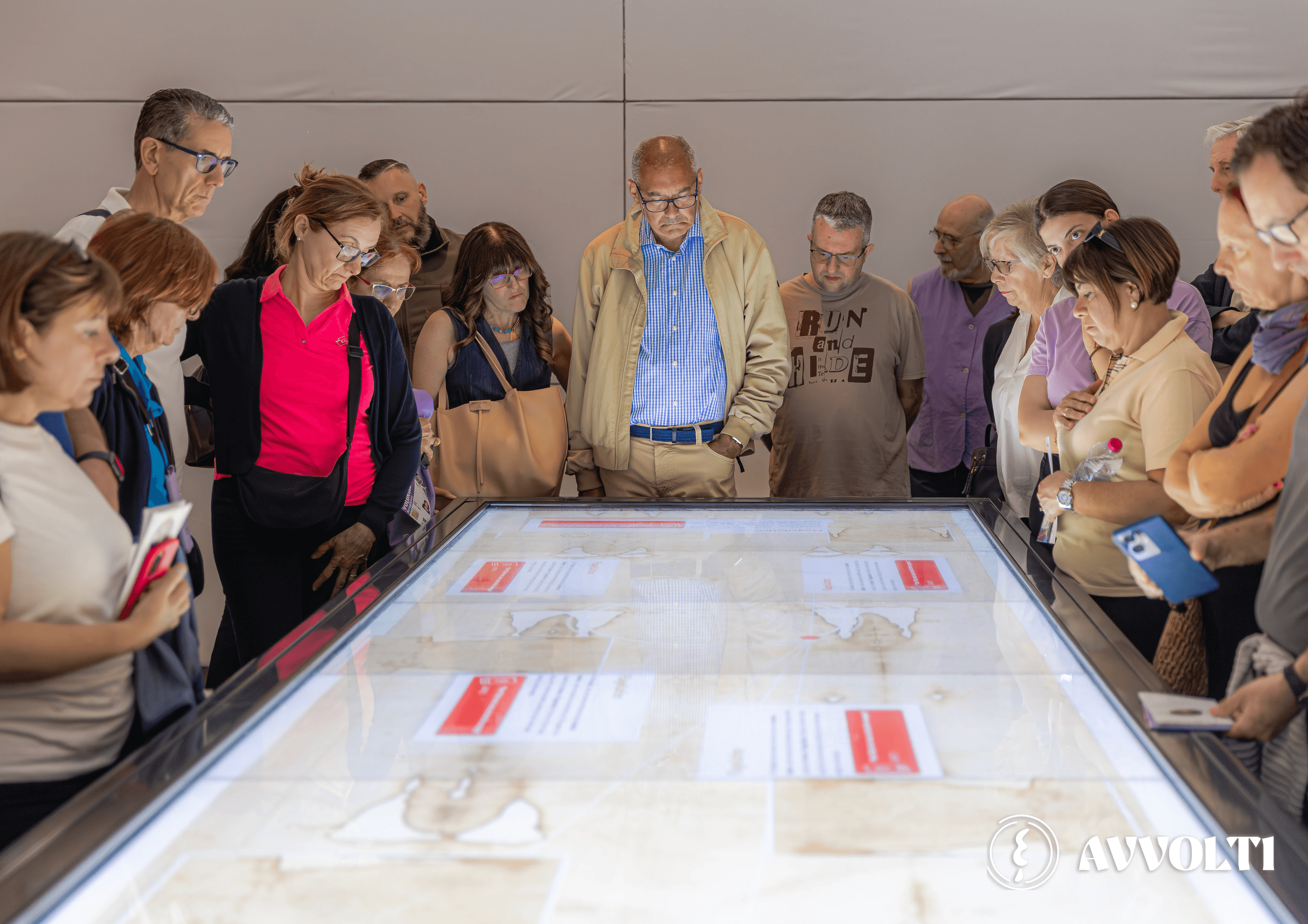 Visitatori del padiglione osservano il tavolo interattivo e leggono le informazioni sulla Sindone