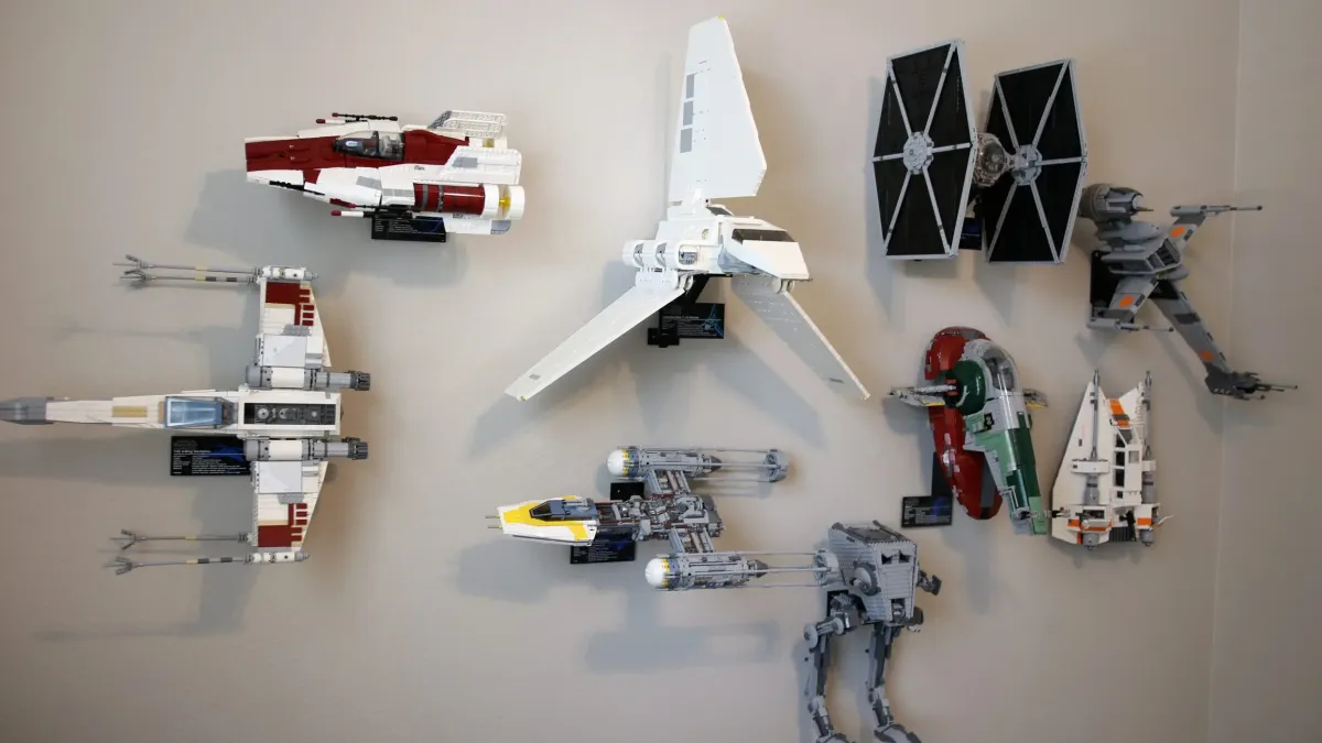 8 LEGO starfighters hanging on a wall thanks to 3D printed mounts from Ultimate Display Solutions on Etsy.