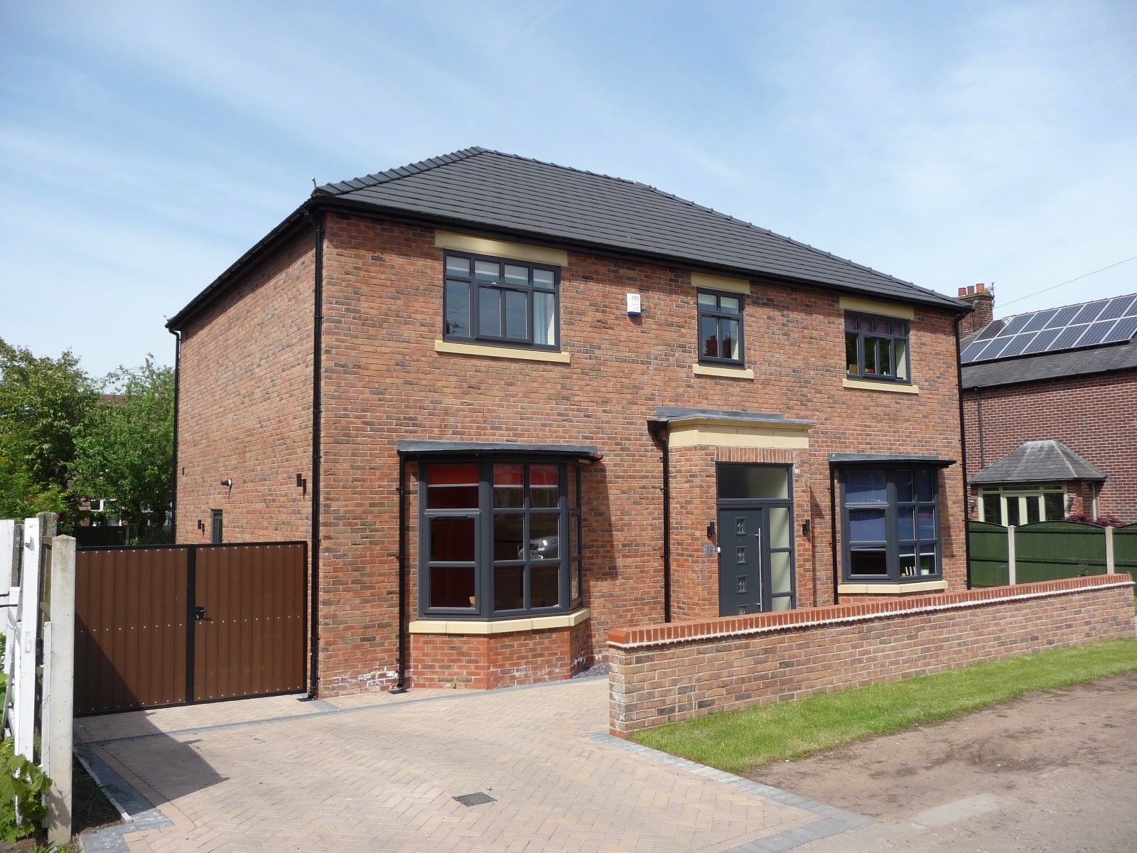 New build two-storey detached house in Didsbury, Manchester, featuring brick façade, bay windows, and modern detailing.