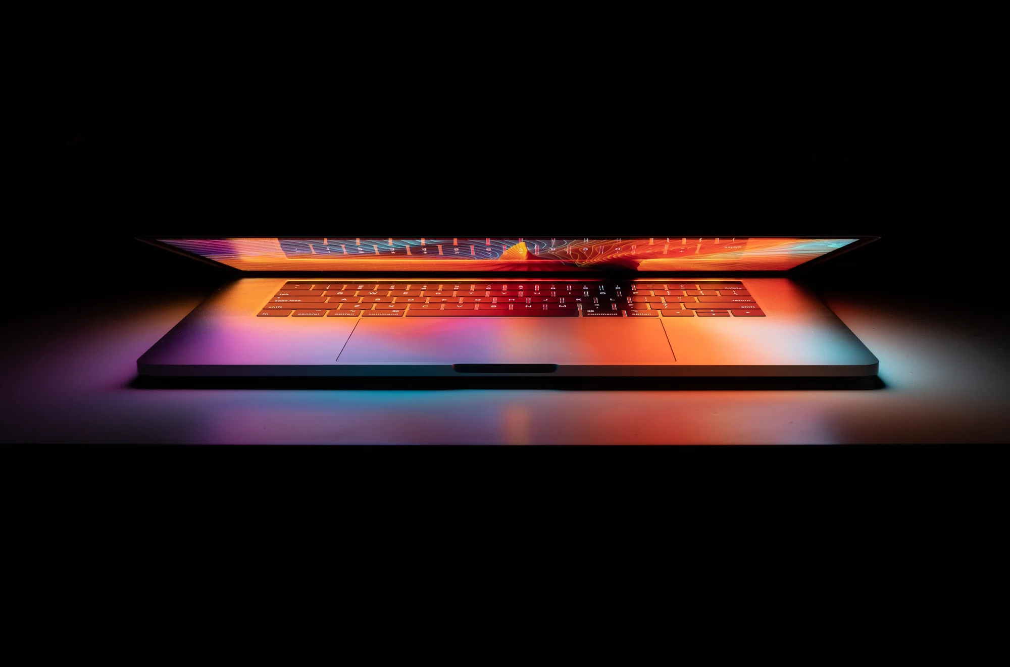 Laptop illuminated with colorful gradient lighting on keyboard and screen