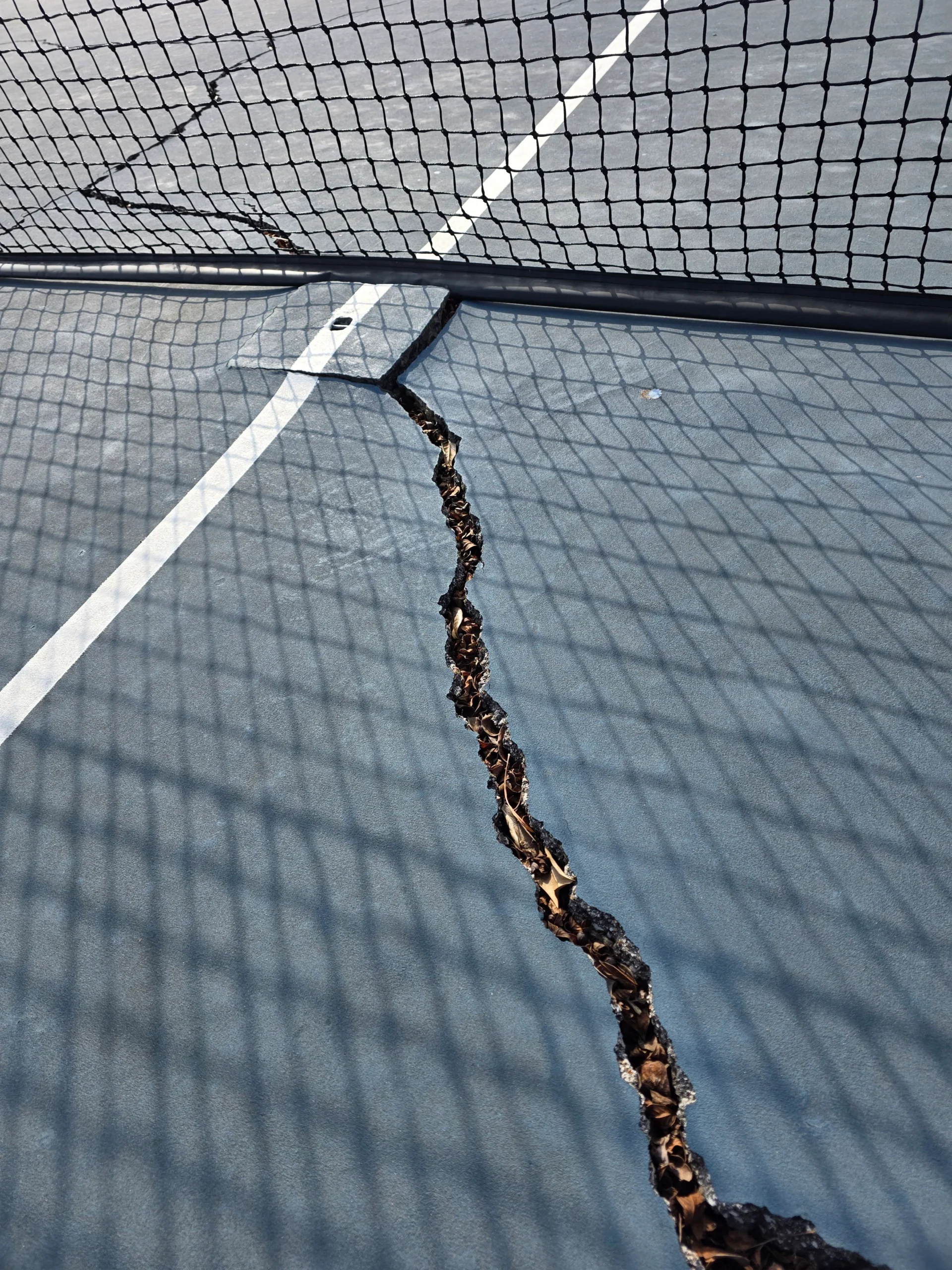 Close-up of wide seam crack running through the court surface before resurfacing at Weston Ranch in Madison, AL