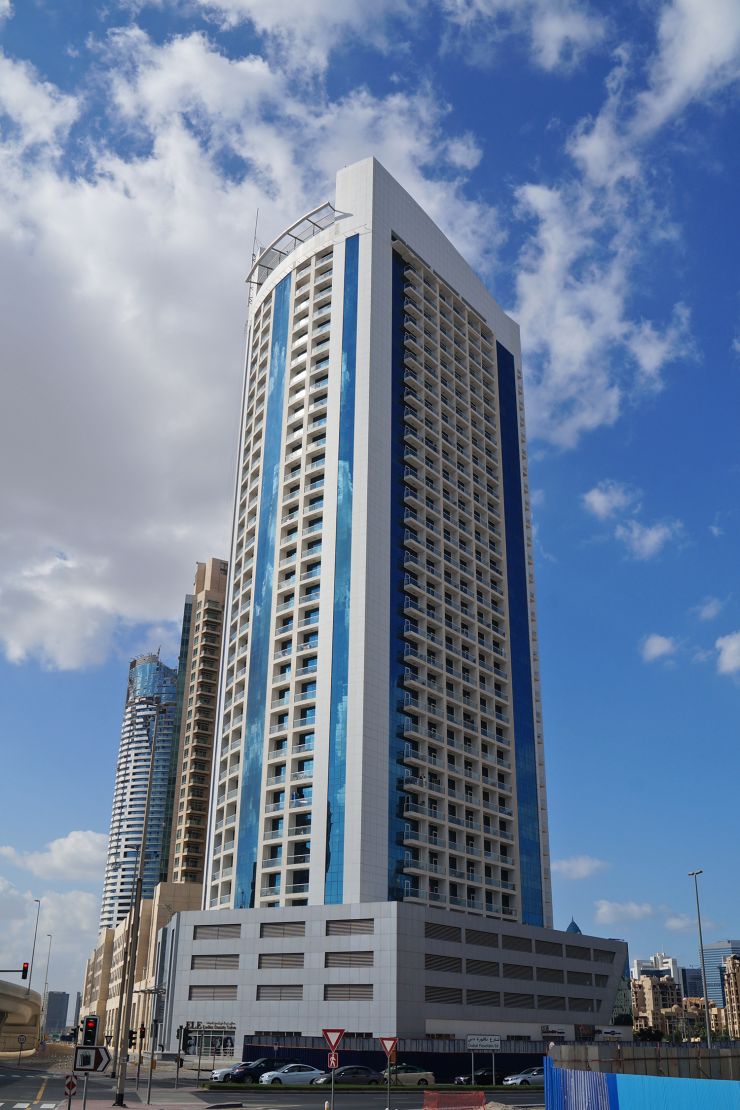 Burj Al Nujoom under a blue sky. Reach out to our specialized real estate agents for the latest property listings.