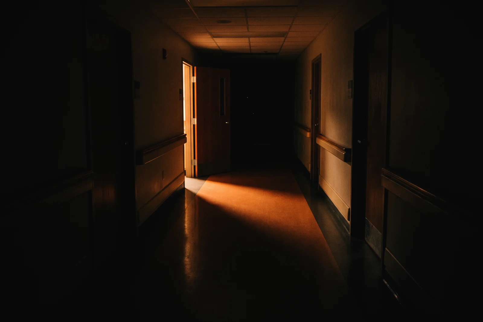 An empty clinic corridor with light falling across the floor