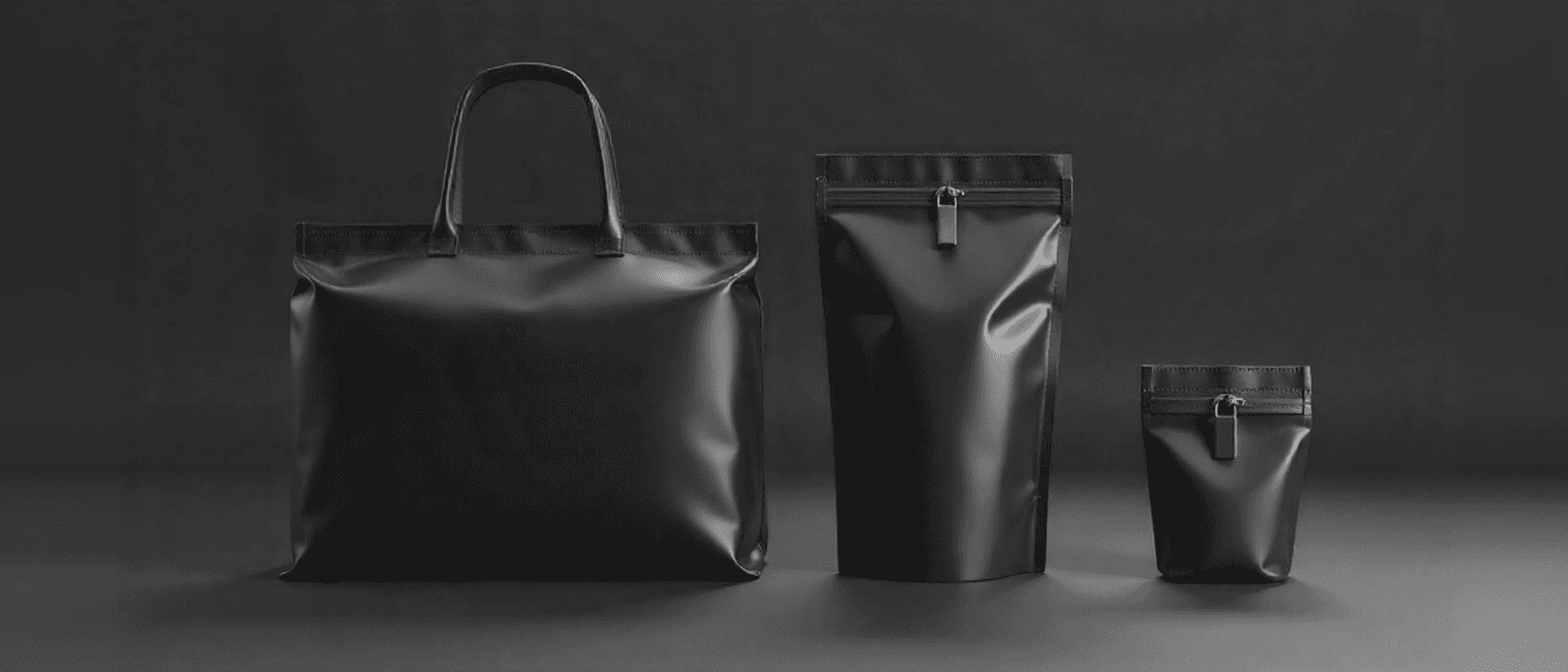 Black and white photo of branded merchandise including a tote bag and pouches.