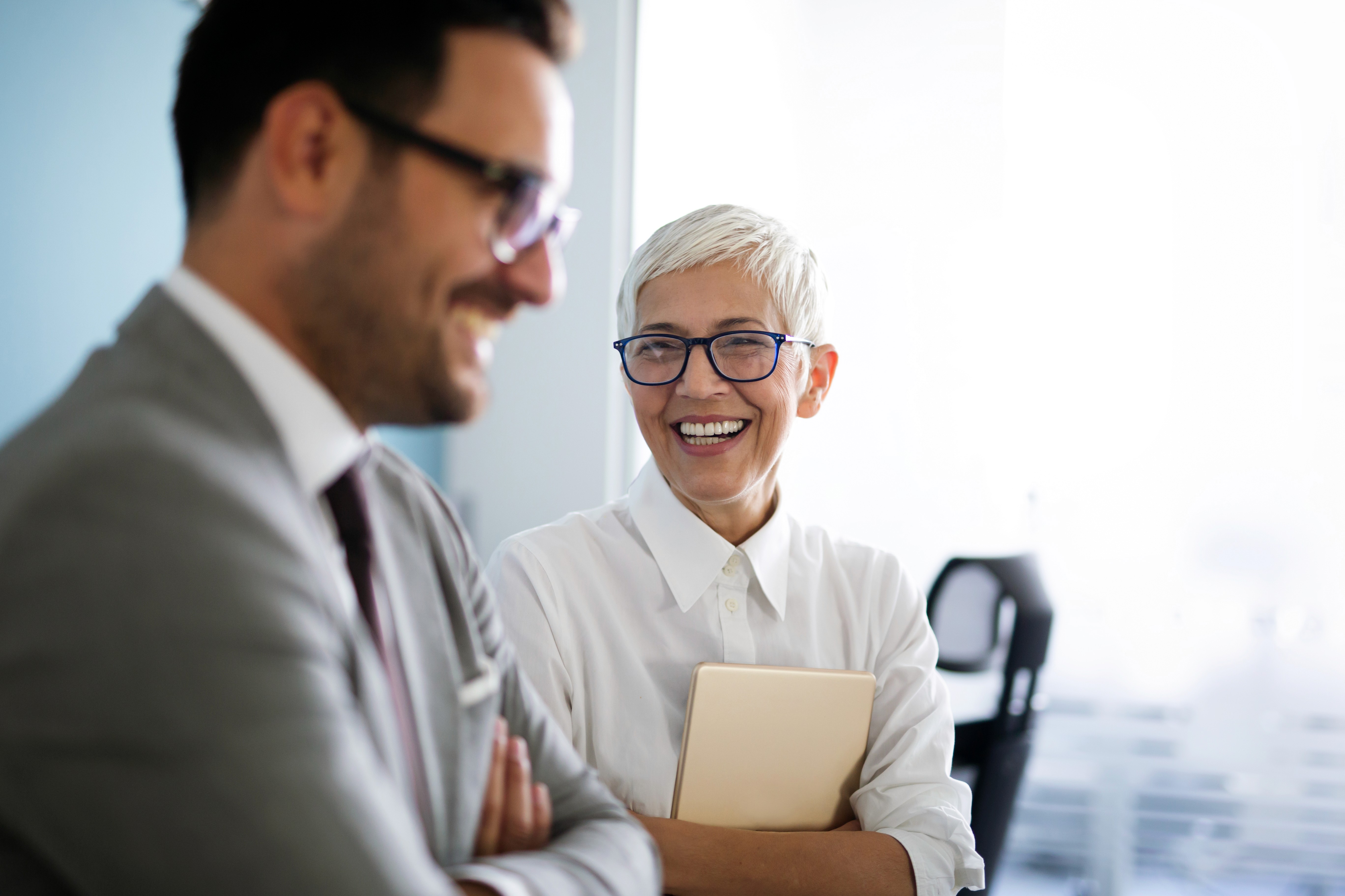 a man and a woman shaking hands in front of a laptop