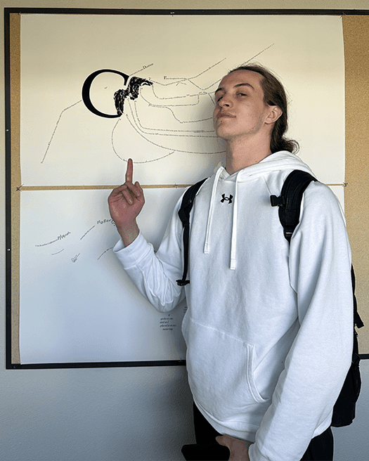 Me pictured next to my monogram print, pointing up to it on the wall.