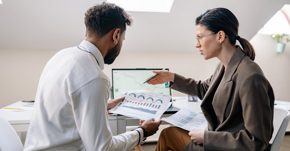 Colleagues in an office setting reviewing charts and graphs for a business presentation.