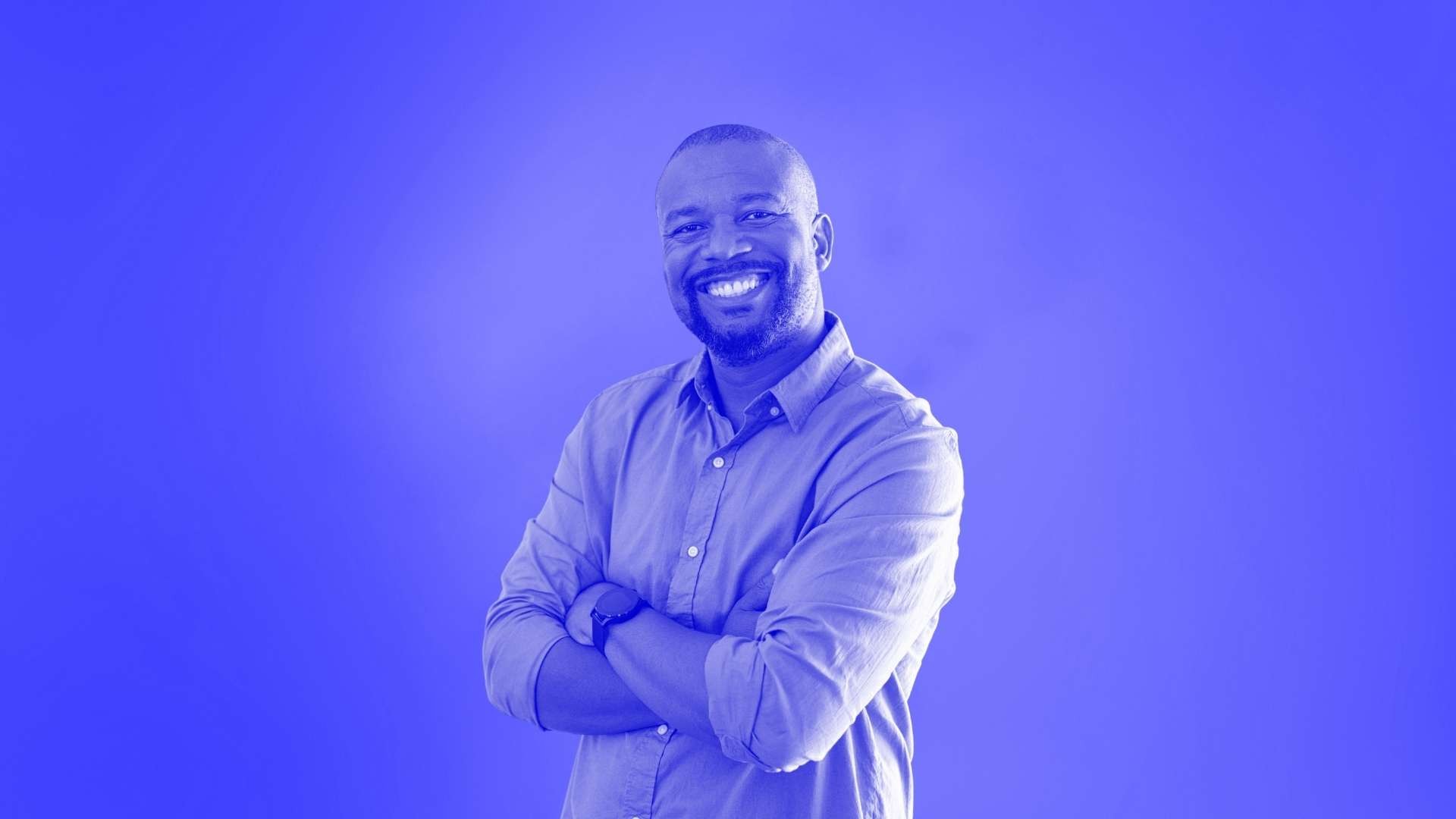 A man smiling and folding his arms