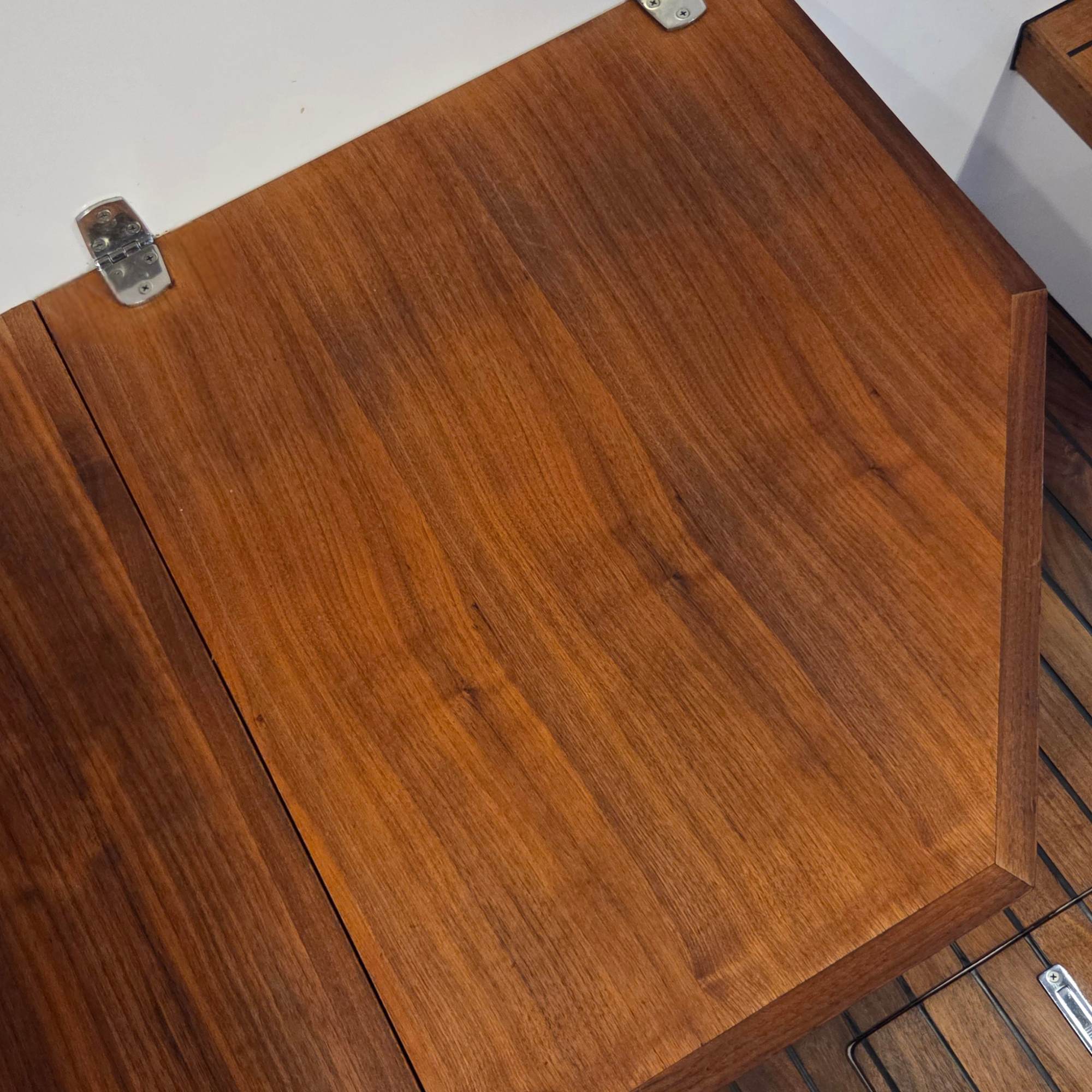 Teak flooring on the inside of a boat that is freshly restored and renewed to a hydrated showroom condition