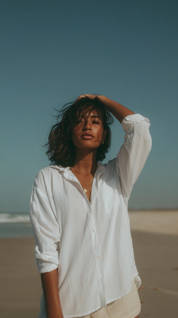 KI-Visual: Model im weißen Hemd am Strand