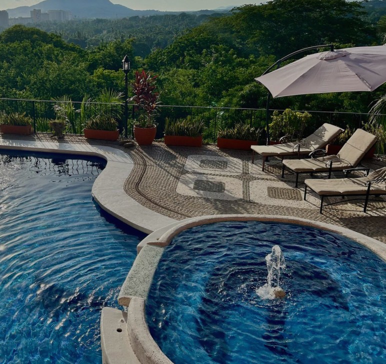 pool surrounded with trees and gazebos