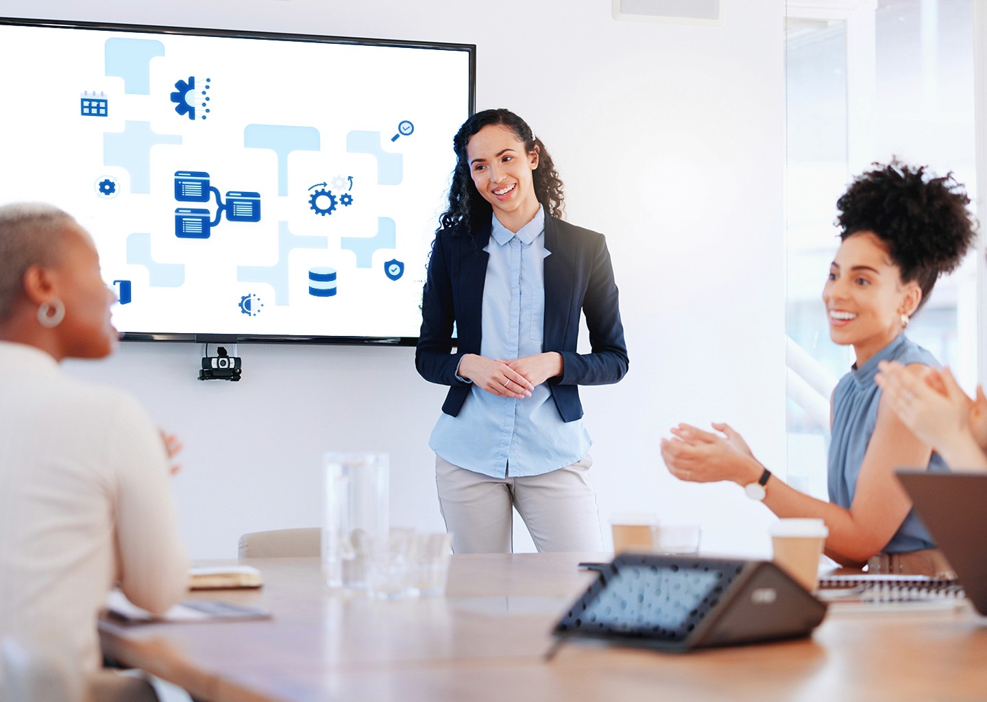 Riunione in una sala aziendale sul monitor un responsabile sta mostrando un grafico con le icone che simboleggiano i gestionali e le integrazioni uno con l’altro