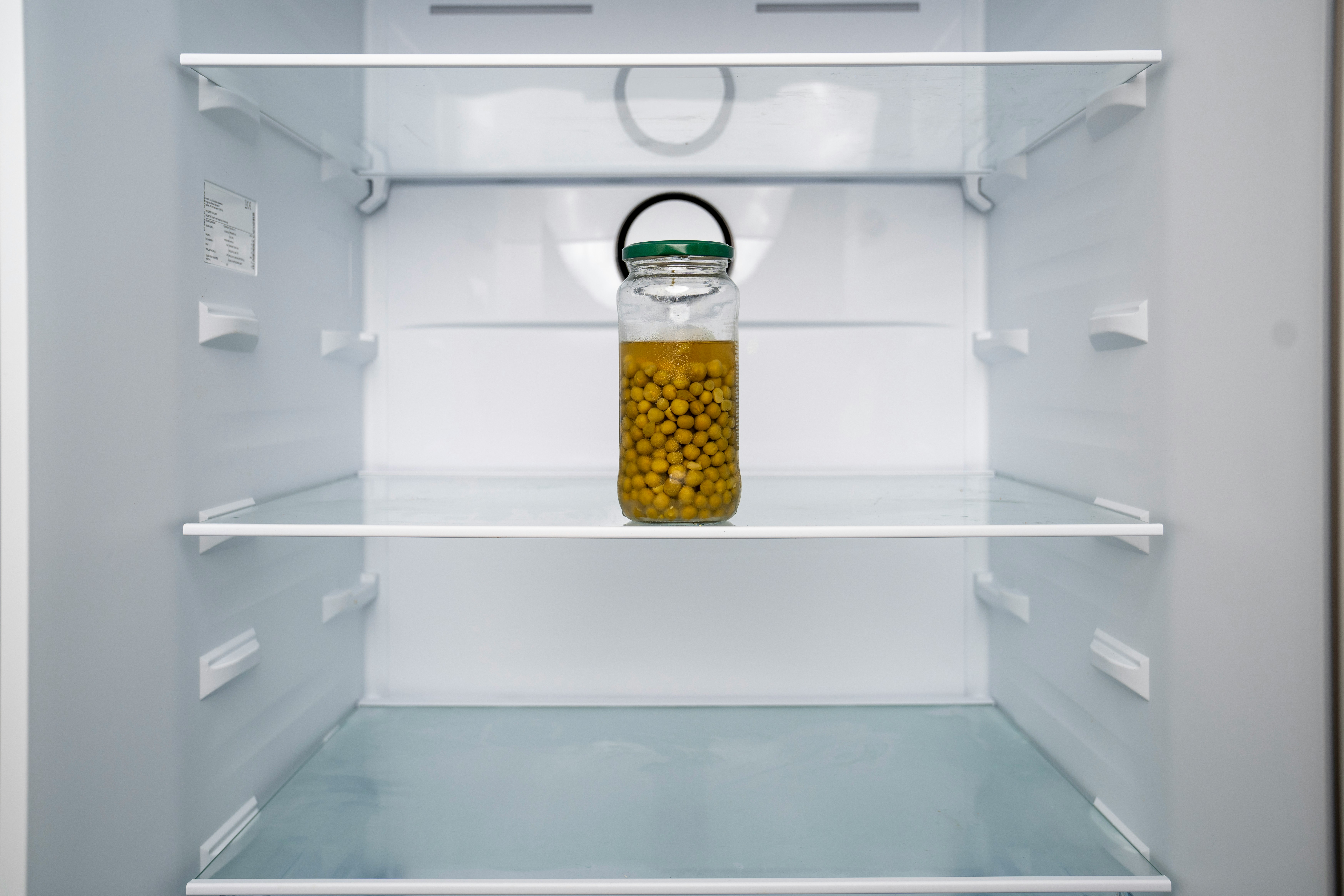 An open refrigerator with a jar of mustard in it