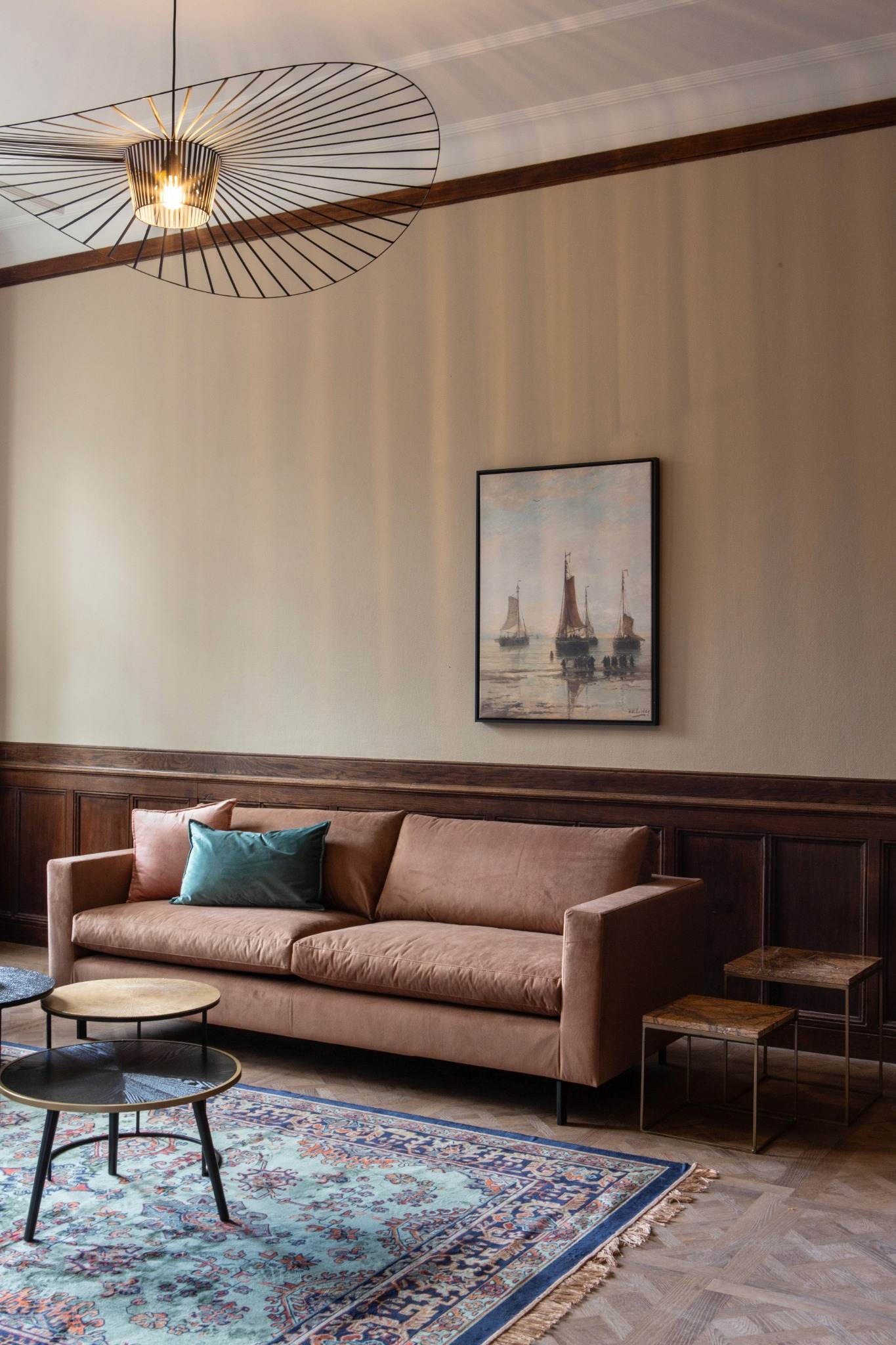 cognac kleurige bank met vintage vloerkleed en oude meester aan de muur