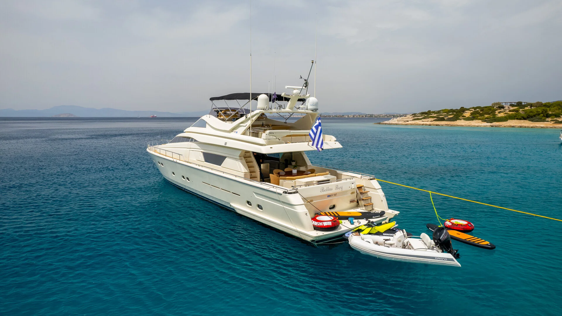 White Rock 36 speedboat with captain at helm cruising calm blue waters near Paros coastline with hills in background.