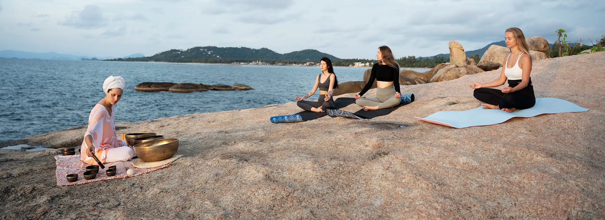 Assorted glass bottles with herbs, tinctures, and homeopathic pellets on a rustic wooden surface, surrounded by fresh flowers, evoking a natural, soothing vibe.