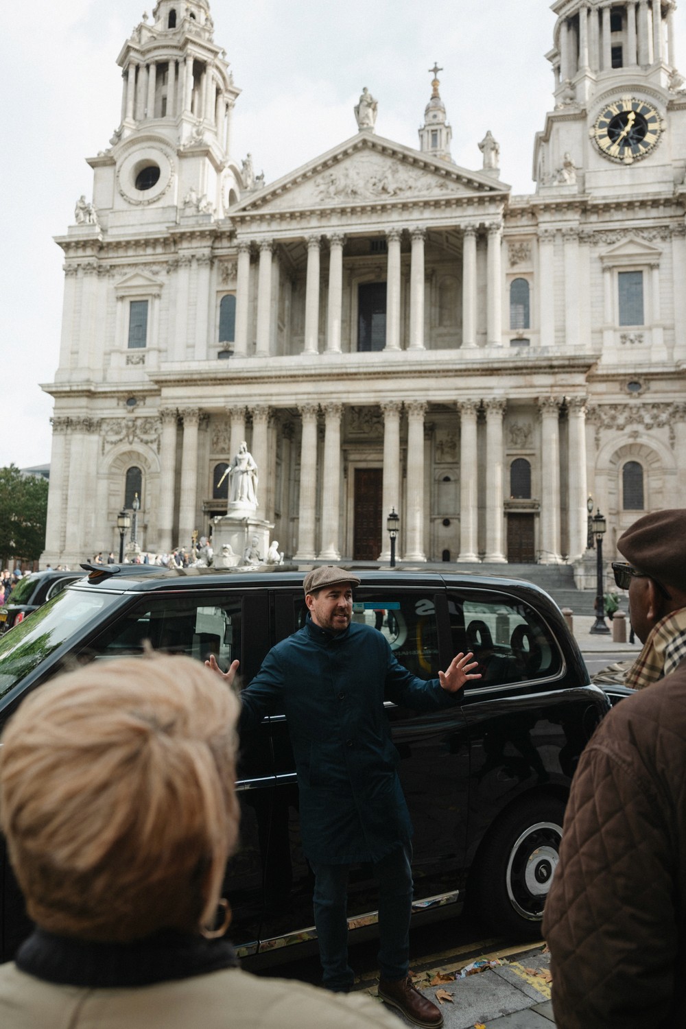 A London taxi tour guide parked in front of St. Paul's Cathedral telling a story 
