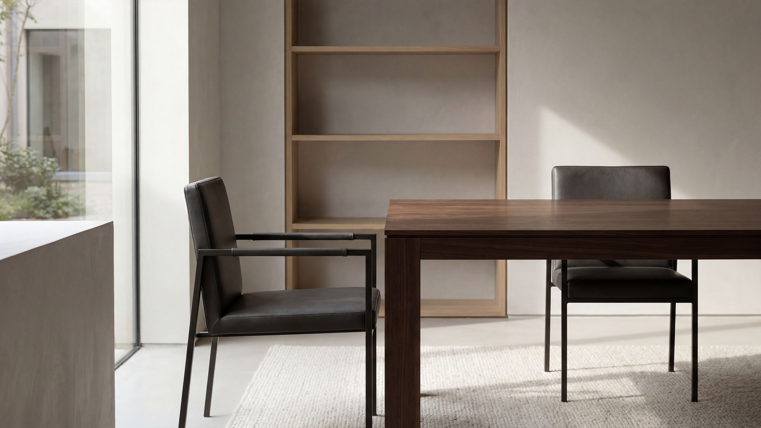 Minimalistischer Besprechungsbereich mit Holztisch, Lederstühlen und Tageslicht