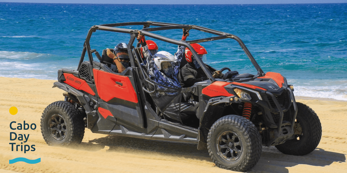 "Off-road adventure vehicle on a sandy beach, offering thrilling tours in Los Cabos with Cabo Day Trips logo."