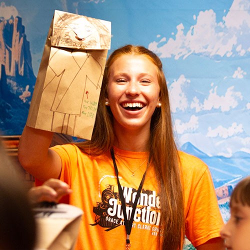 volunteer laughing while holding a Bible