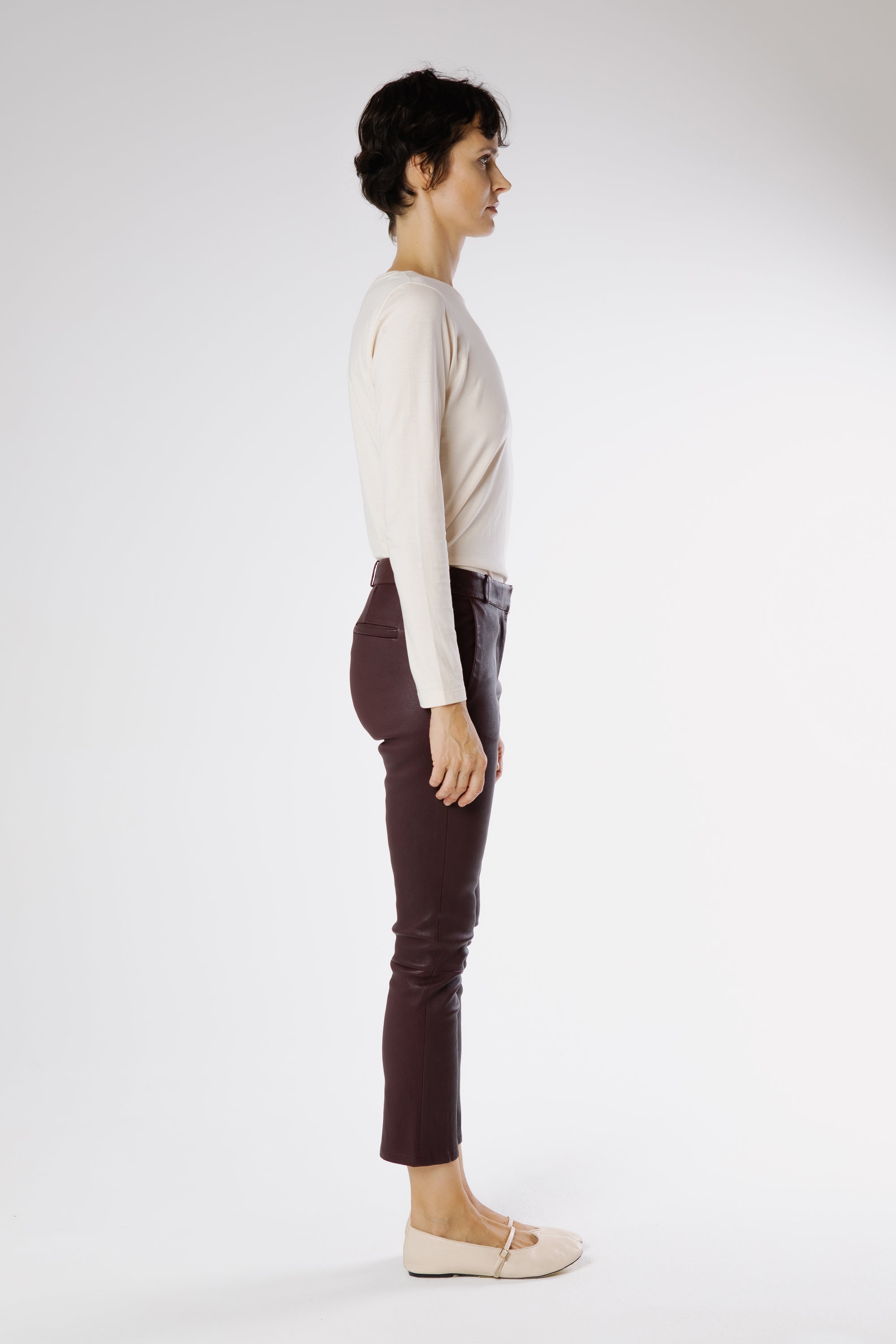 Side view of Marina leather trousers in Bordeaux highlighting sculpted leg line