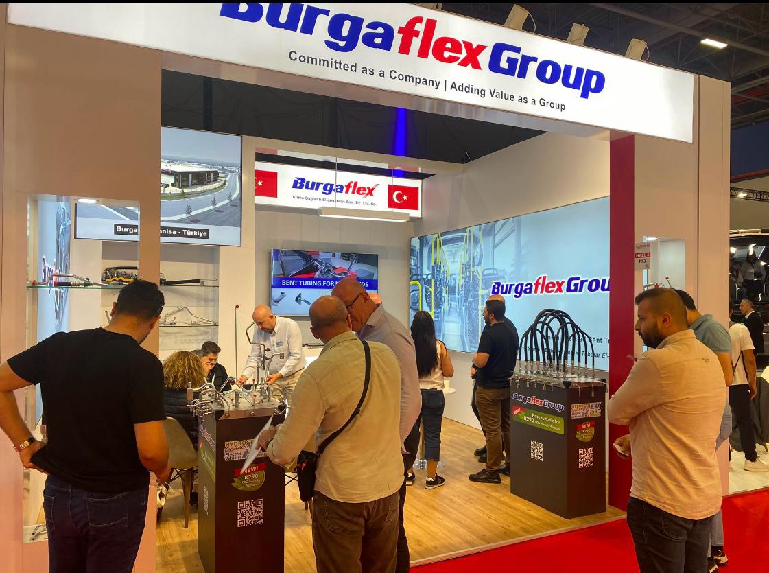 Burgaflex exhibition stand at Busworld 2026 Istanbul, featuring a clean white structure with blue and red vertical accents and illuminated header signage.
