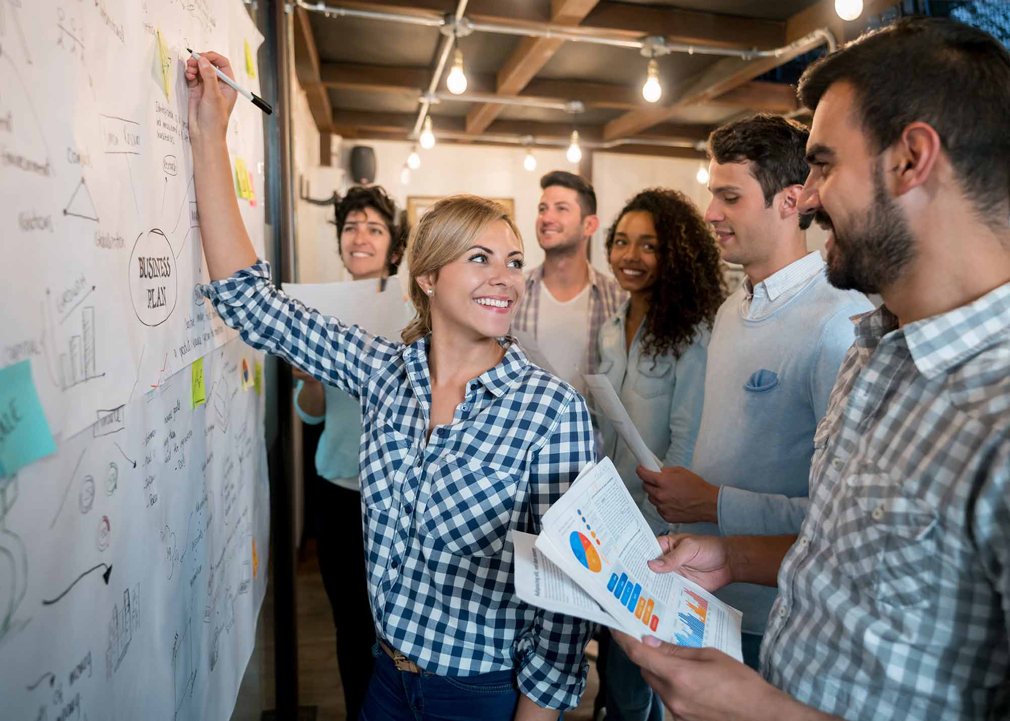 Dynamic e-commerce team standing in front of a large whiteboard