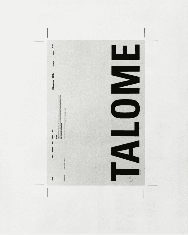 Smiling young man with short hair poses against a dark background, wearing a green button-up shirt.