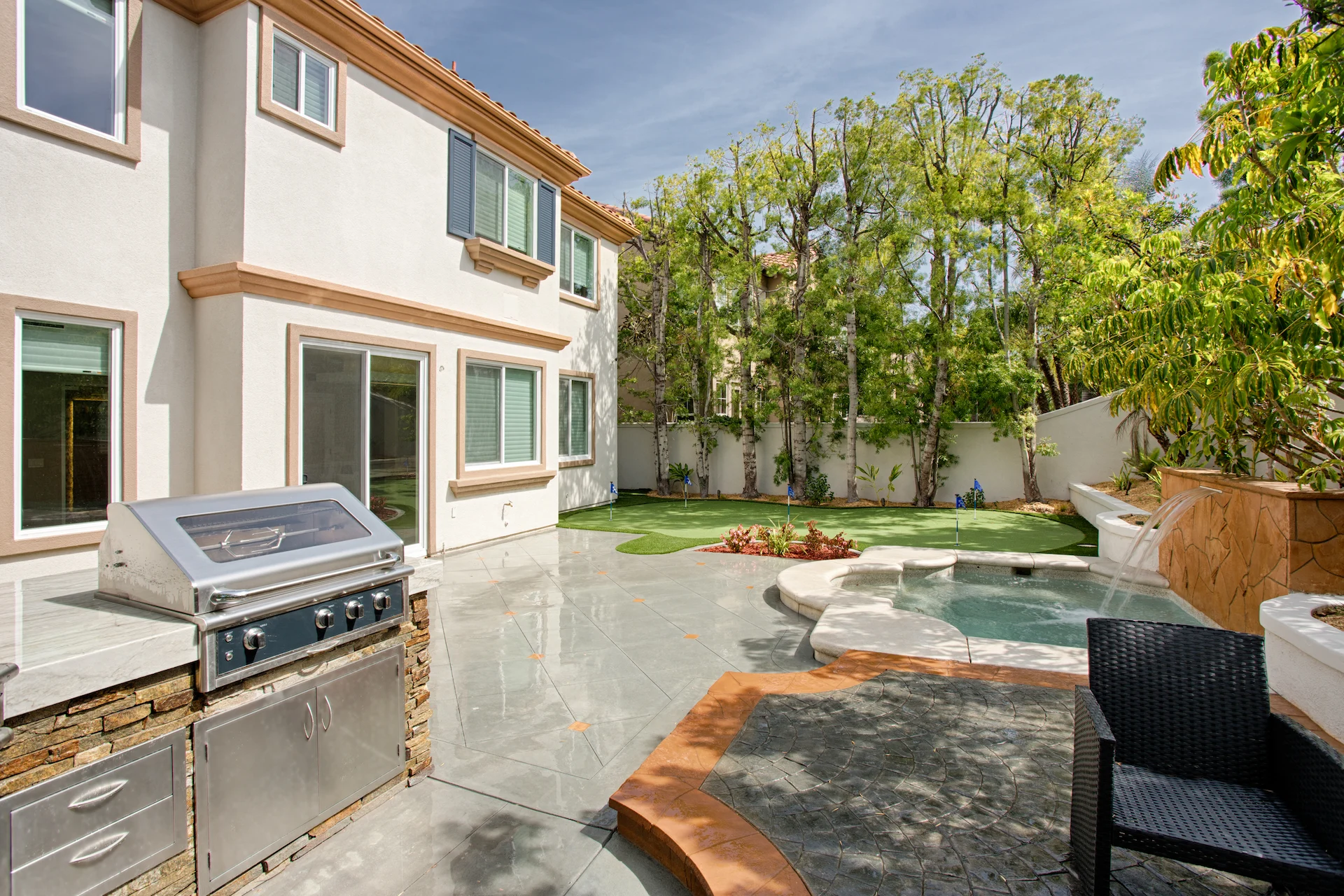 View from angle 2 of the putting green and outdoor kitchen, showcasing the perfect blend of recreation and entertainment in the Harbor Cove remodel.