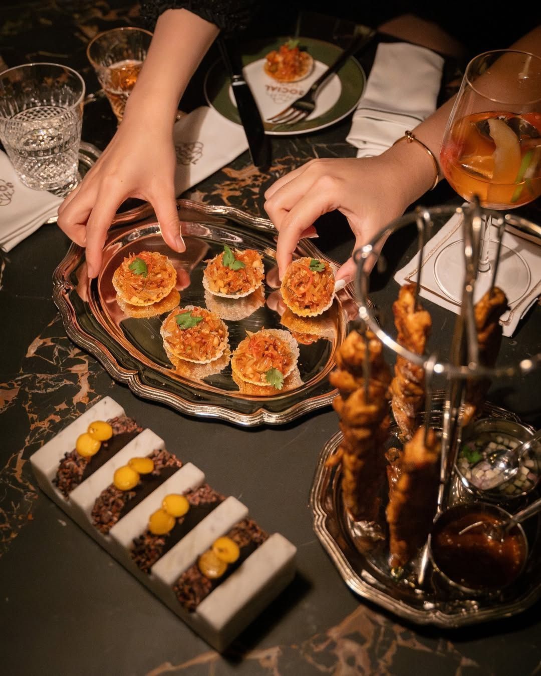 Elegant Indian canapés and small plates served on marble, illustrating the precision, plating artistry, and technique driven approach behind modern Indian cooking at Dhoom.