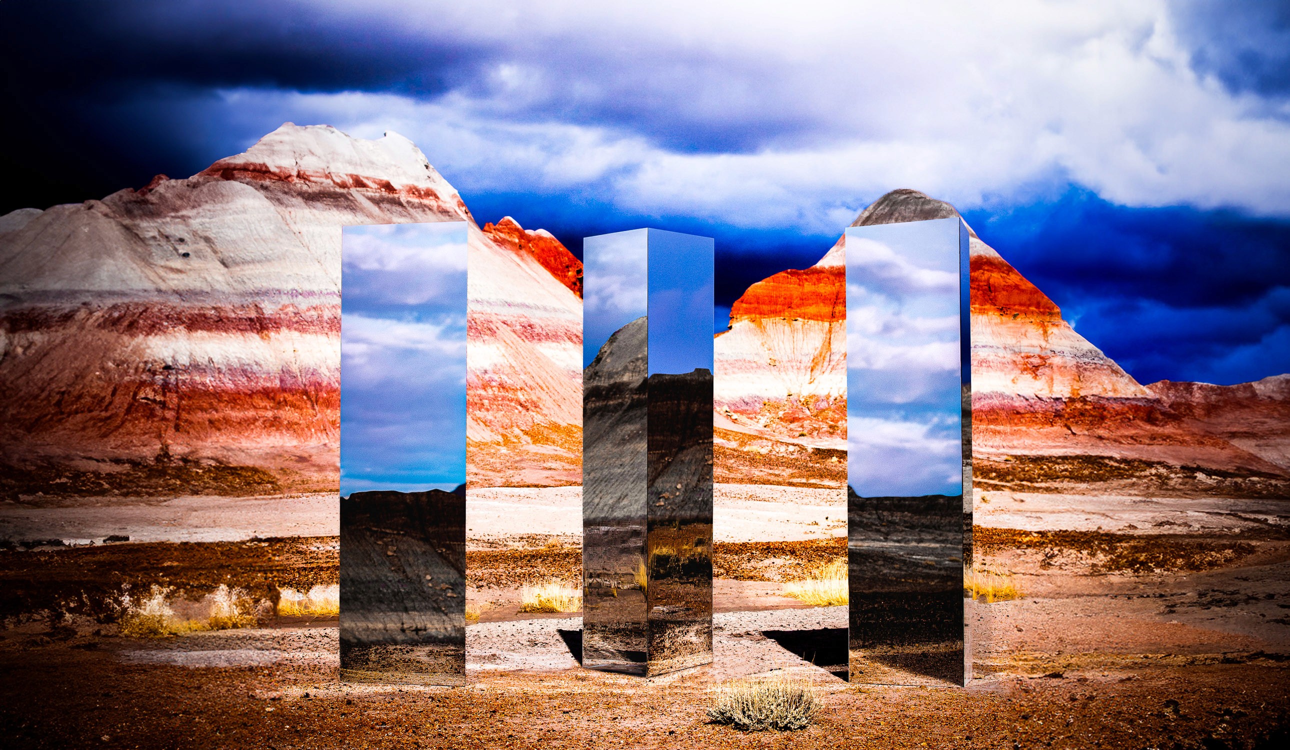 Three mirror monoliths designed by creative director Owen Brown in front of The Tepees at Petrified Forest National Park