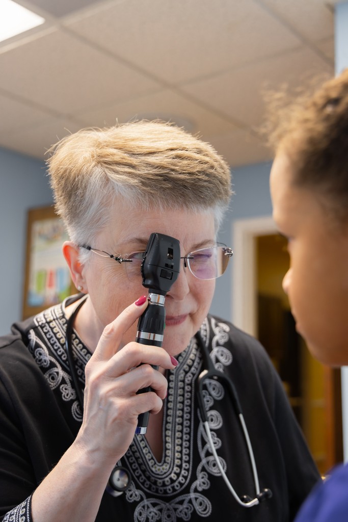 Dr. Ermer examining the eyes of a young patient.