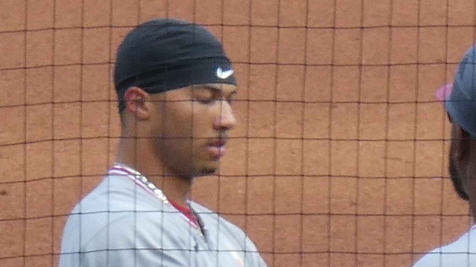 Close-up of Daylen Lile in a Nationals road jersey and black cap, face centered