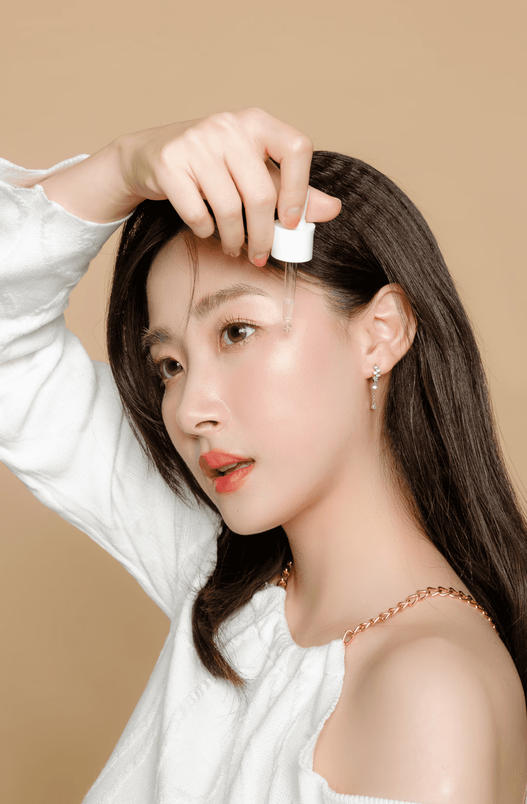 Portrait of a woman with long red hair and closed eyes, gently touching her face with both hands