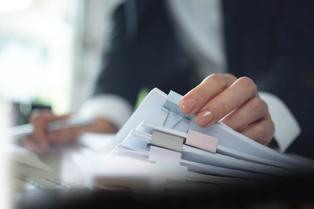 A person in a suit holds a stack of papers, appearing... and ready for a professional discussion or meeting. Form I539