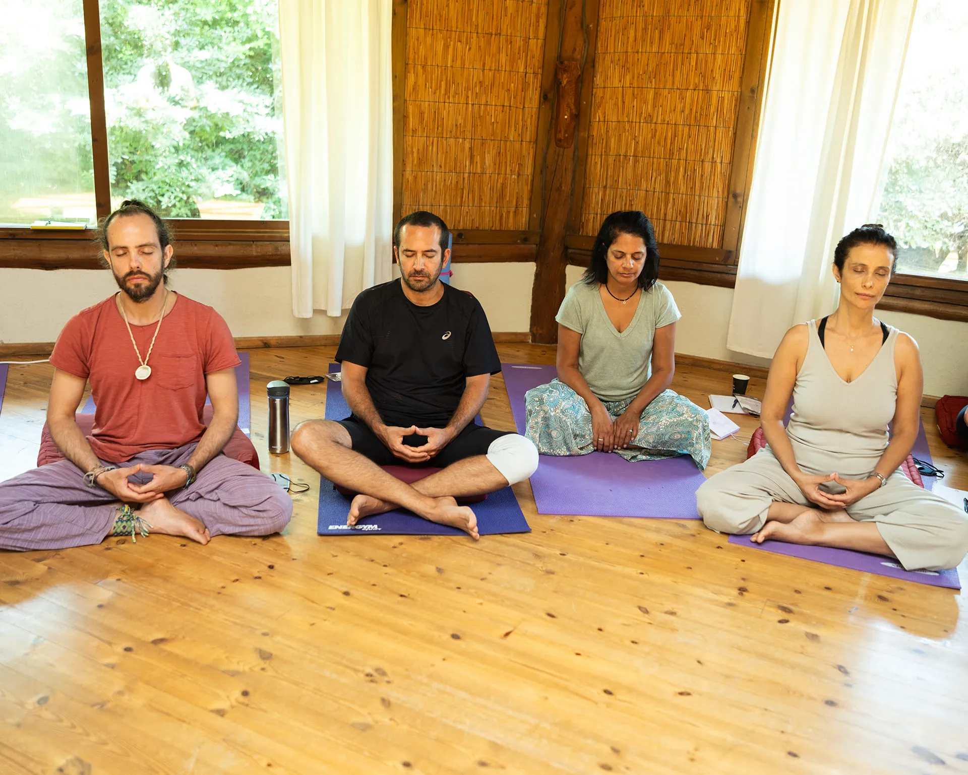 2 men and 2 woman seating in a meditation position
