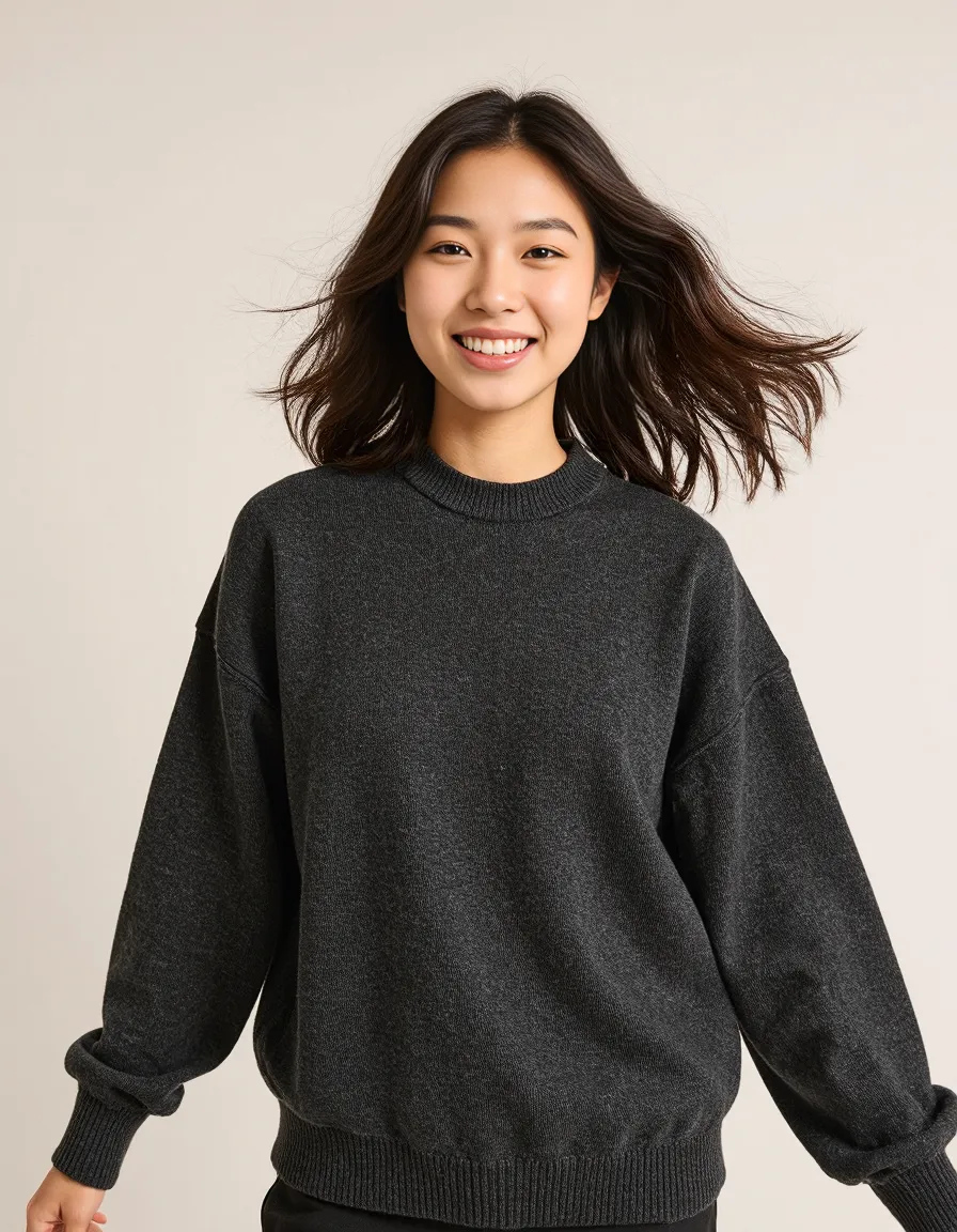 Portrait featuring a person in a dark gray sweater against a neutral background with soft lighting and natural hair movement