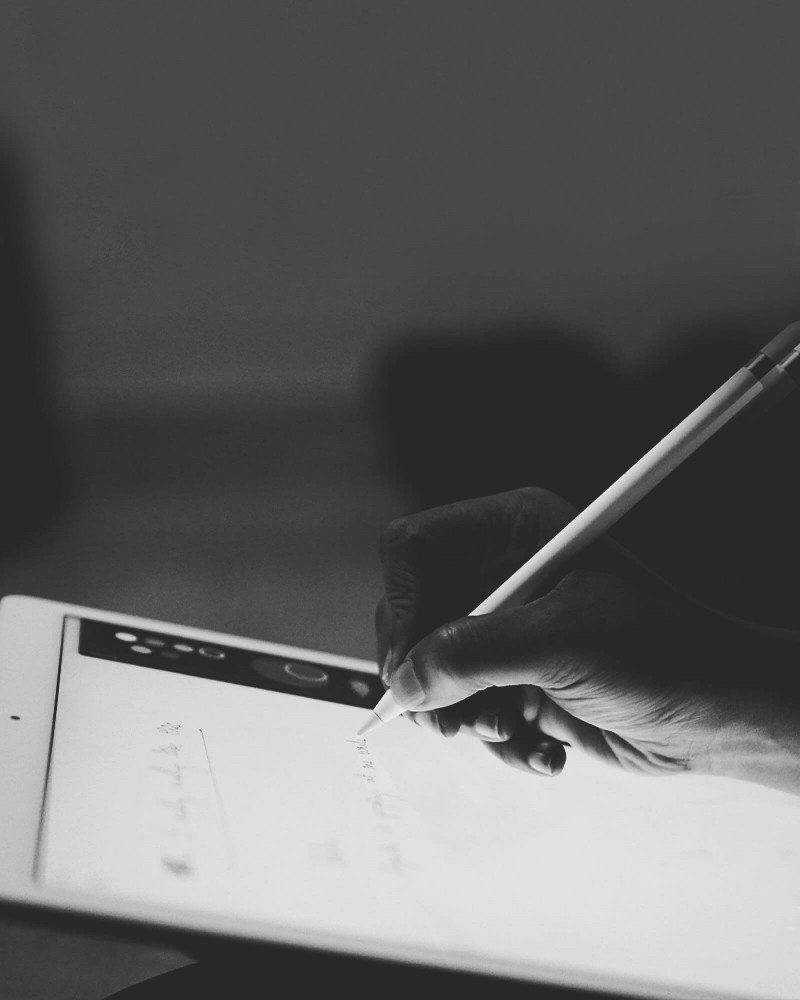 Visual for Design Service. Hand using an Apple Pencil on an illuminated iPad screen, representing UX/UI and digital product design.