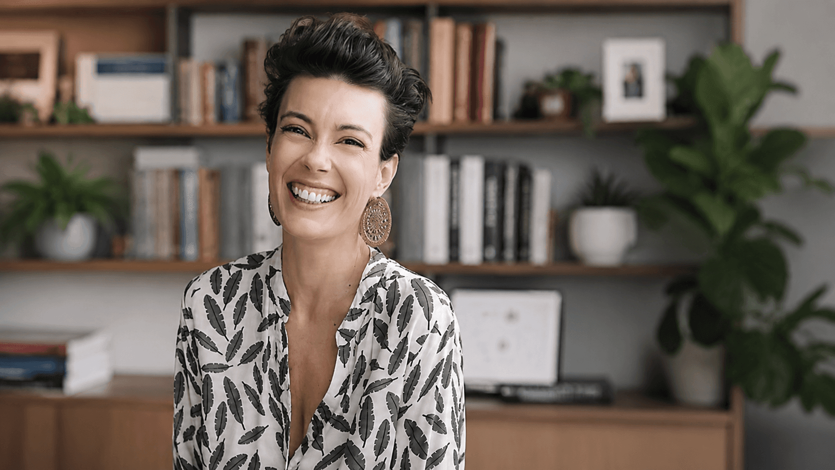 Professional headshot of a business advisor in a white shirt, smiling confidently against a warm neutral background.