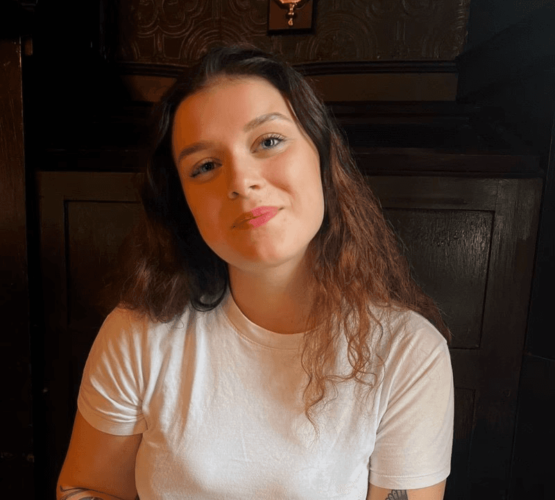 Woman in white shirt smiling at the camera