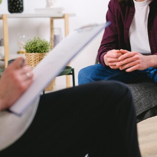 A person writing while another is sitting