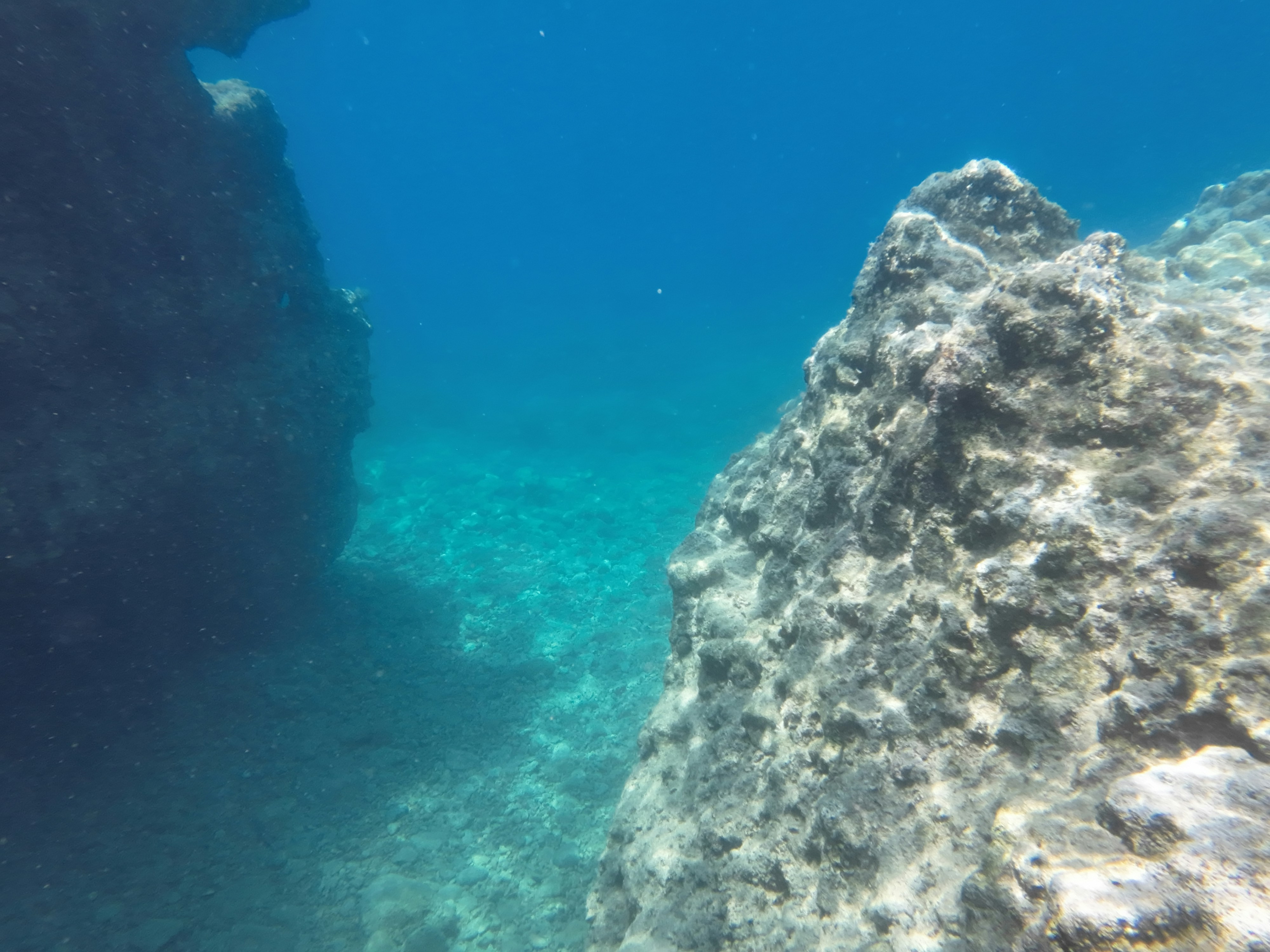 a rocky cliff with a body of water below