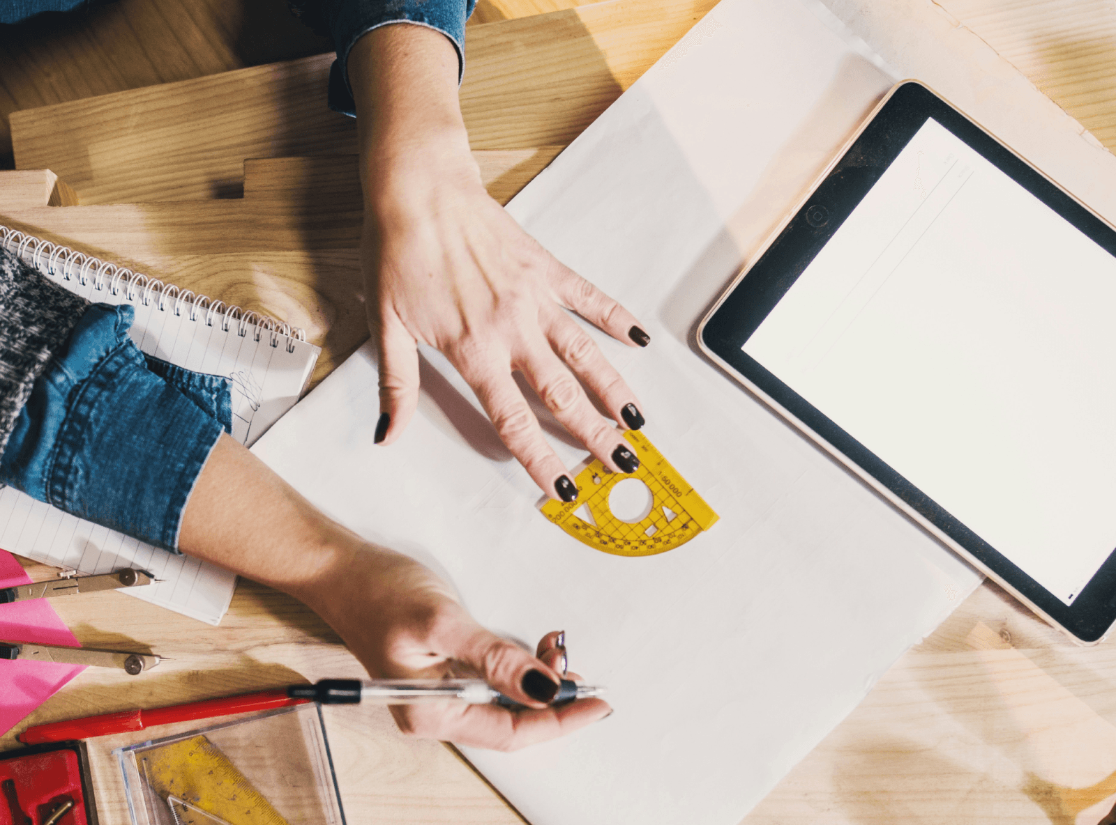 Person drawing a design with a protractor.
