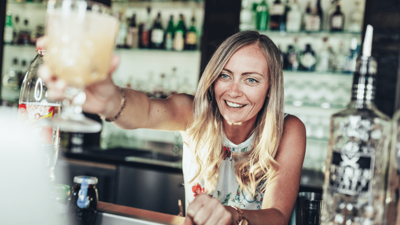 Virtueller Cocktail und Pasta-Workshop – Barkeeper serviert frisch gemixten Drink während des Live-Events.