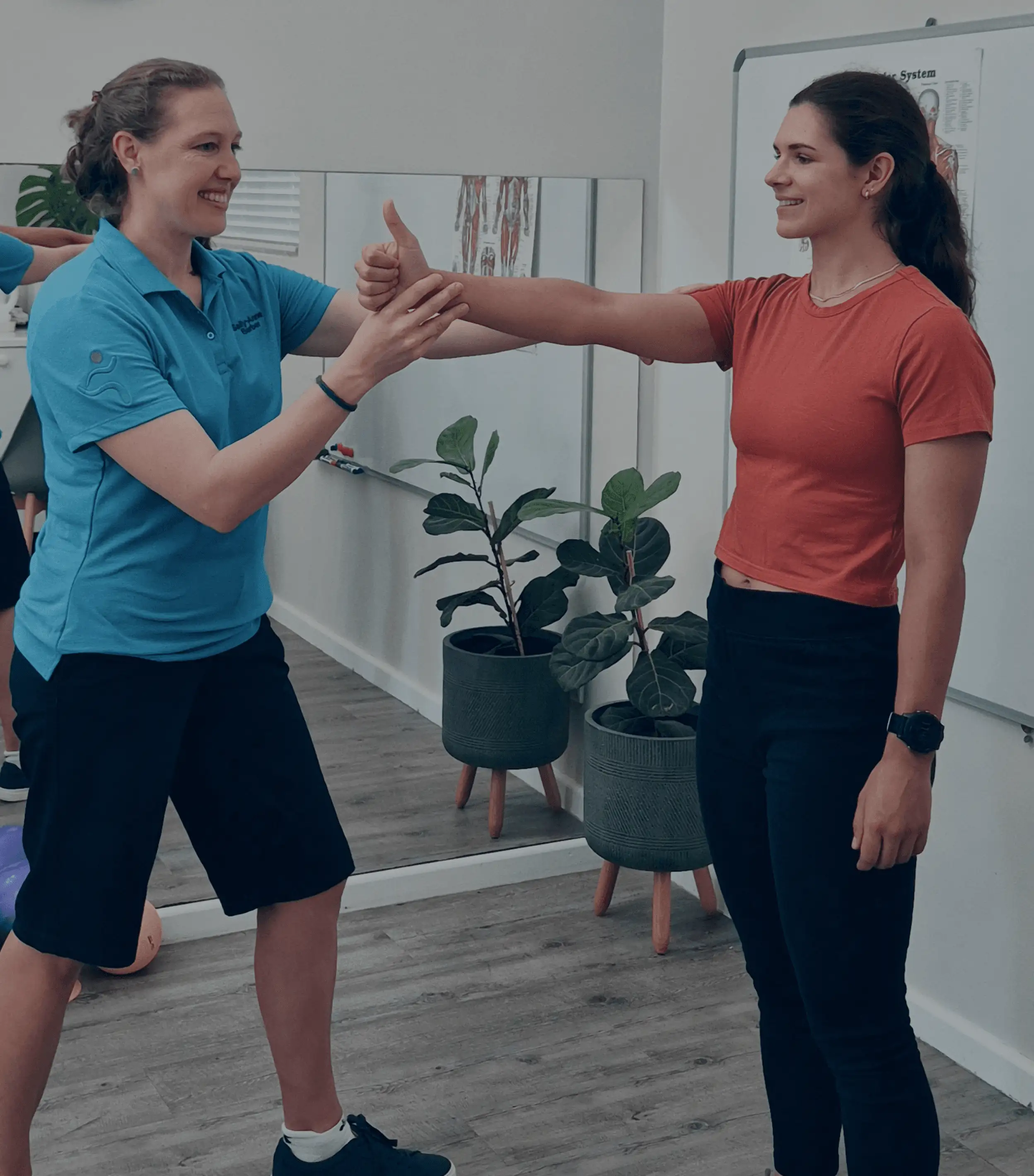 Two women are engaged in a training exercise, demonstrating a motion sensitivity technique for concussion treatment.