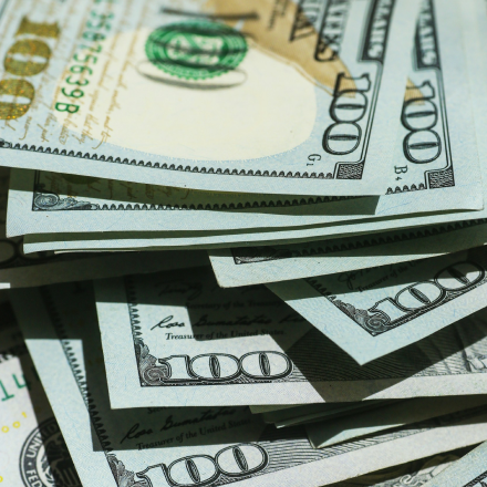 Close-up of U.S. dollar bills representing money and financial costs.
